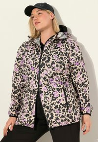Leopardmönstrad jacka i beige, svart och lila, med dragkedja framtill, huva och elastiska ärmslut. Har sidofickor och en lätt textur.