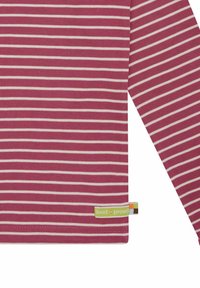 Camicia a maniche lunghe di un rosa intenso con strisce orizzontali bianche, con un piccolo etichetta sull'orlo con testo verde in grassetto. Tessuto morbido.