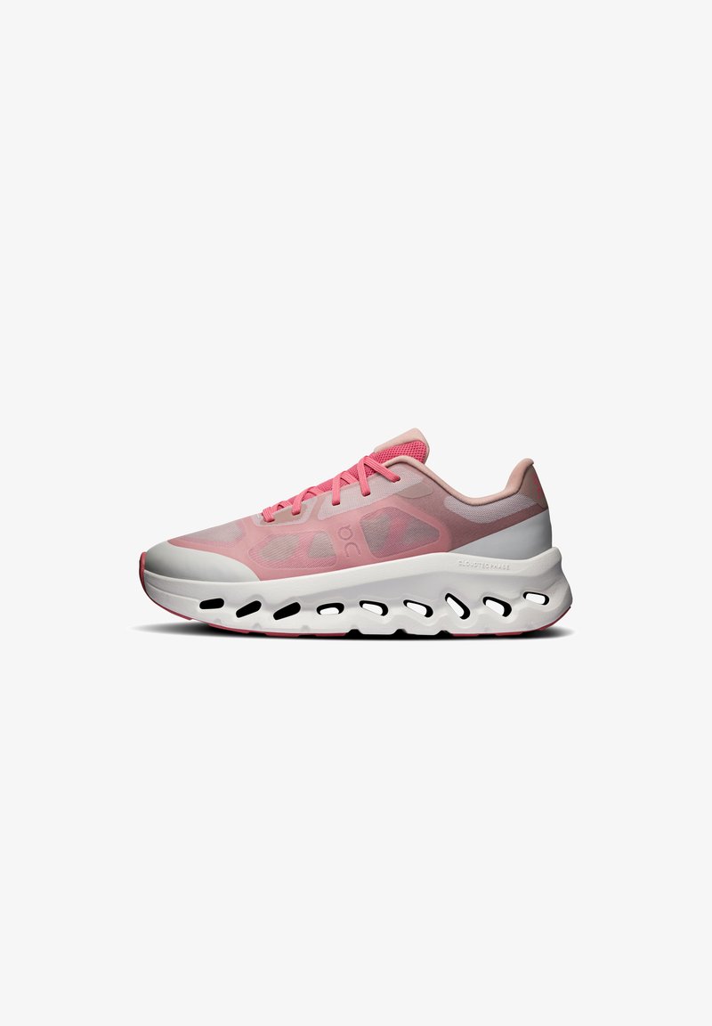 Une seule basket de sport rose avec une semelle blanche, des détails découpés noirs et des lacets roses sur fond blanc.