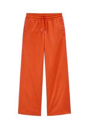 Voľné oranžové tepláky s elastickým pásom, sťahovacou šnúrkou, bočnými vreckami a kontrastnými ružovými pruhmi pozdĺž vonkajších švov.