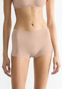 Nude cotton-blend boyshorts with a smooth texture, elastic waistband, and mid-rise cut, providing a comfortable fit.