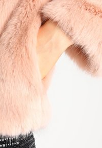 Rosa fuskpälssleeve med mjuk textur och en slät yta, som visar en naturlig drapering. Den har ett tjockt, plyschigt utseende.