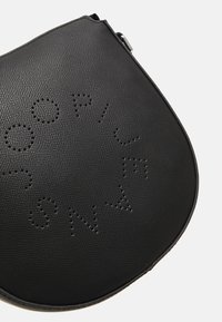 Borsa a tracolla nera in pelle con una texture a granulato, caratterizzata da un motivo di lettere stampate. Ha una forma arrotondata con chiusura a zipper superiore.
