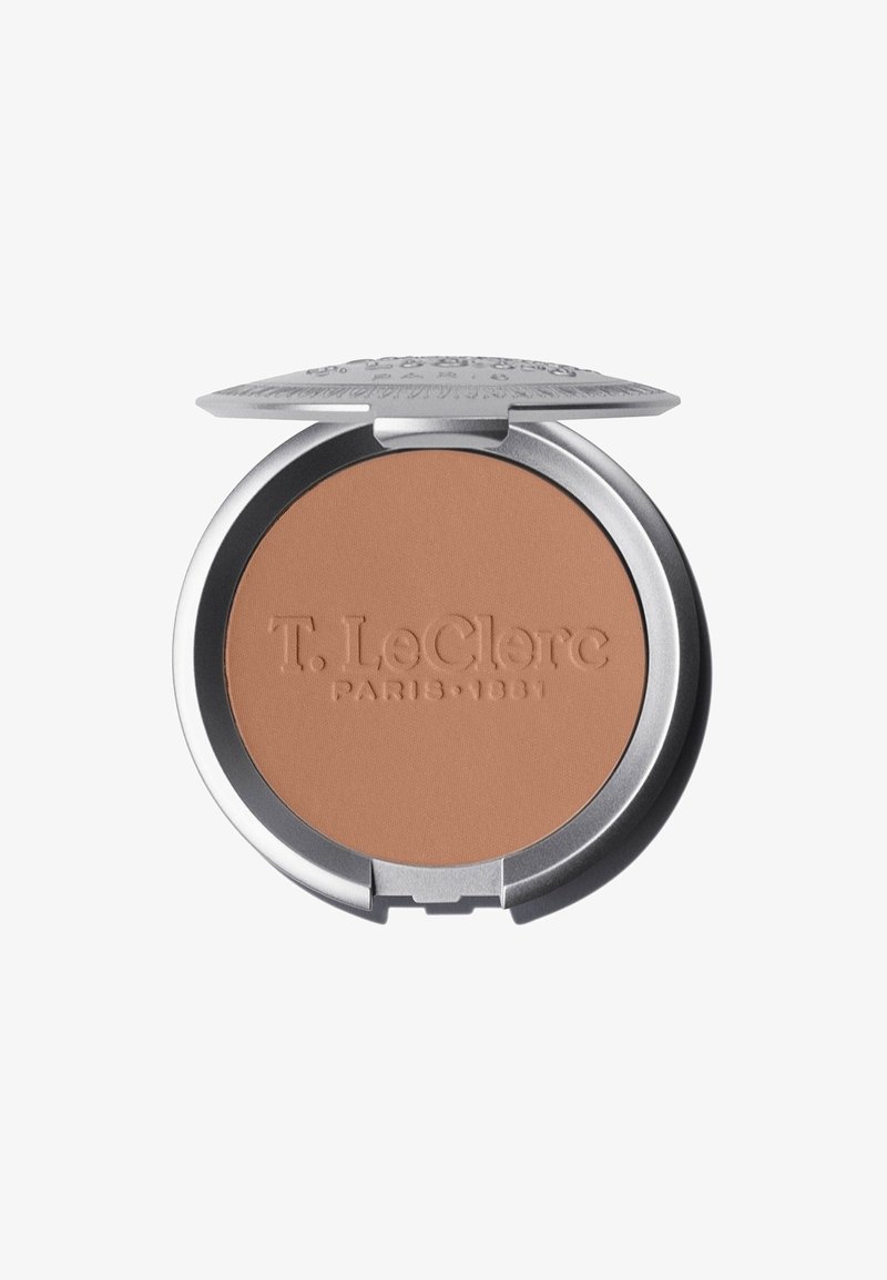 Kompakter Bronzer in einer runden silbernen Dose. Glattes, mattes beigefarbenes Produkt mit eingeprägten Markendetails auf der Oberfläche. Klappdeckeldesign.