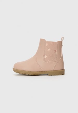 Bottine rose clair avec semelle beige, panneau latéral élastique avec motifs d'étoiles en relief, et languette arrière.