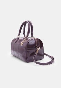 Purple, glossy handbag with a rounded shape, featuring short handles, a detachable strap, zip closure, and textured panel design.