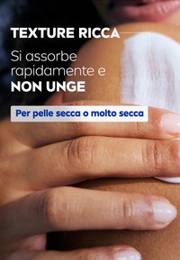 Crema idratante applicata sulla pelle, texture cremosa che si assorbe visibilmente, finitura non grassa. Mani che accarezzano delicatamente un'area di pelle secca.