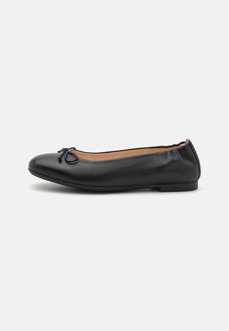 Ballet flat en cuir noir avec bout rond, petit détail en nœud, talon élastiqué et semelle plate sur fond blanc.