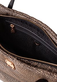 Una borsa a tracolla con un interno a motivo nero e marrone, che mostra una tasca con zip, hardware dorato e un rivestimento in tessuto testurizzato.