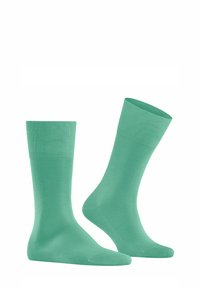 Grüne Baumwollsocken mit einem gerippten Bündchen, glatter Textur und mittellanger Länge, die ein einfaches und einheitliches Design aufweisen.