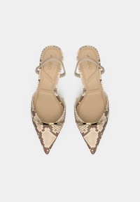 Sandales à talons hauts à bout pointu en imprimé serpent beige avec une tige en cuir lisse, des fines brides autour de la cheville et un accent métallique sur l'avant du pied.