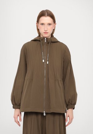 Veste zippée vert olive avec un design plissé, capuche et poignets élastiques. Texture lisse et coupe décontractée, adaptée pour un usage quotidien.