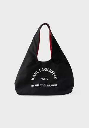 Sort stof-totepose med rød inderforing, med hvid tekst "Karl Lagerfeld Paris 21 Rue St-Guillaume" på forsiden.
