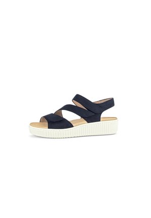 Sandal azul marino con diseño de tiras cruzadas, material superior suave, plantilla acolchada y suela de plataforma blanca gruesa con bordes texturizados.