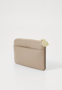 Leather cardholder in light beige with a textured surface, featuring a gold zipper and a front pocket for easy access. Compact design.