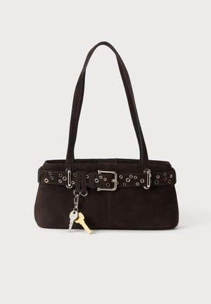 Bolso de ante marrón oscuro con doble asa, un cinturón con ojales alrededor de la parte superior y dos llaves sujetas al frente.