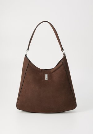 Brown suede shoulder bag with a curved silhouette, featuring a silver accent detail and contrasting stitching along the edges.