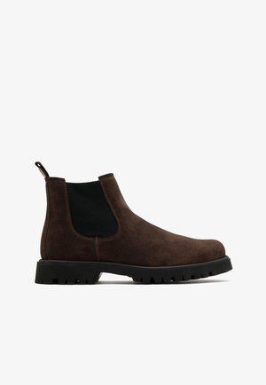 Brązowe zamszowe buty chelsea z elastycznymi bocznymi panelami, teksturowaną cholewką, gumową podeszwą i pętlą z tyłu.