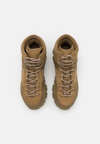 Brązowe buty turystyczne z materiałów siateczkowych i zamszowych. Posiadają wyściełany kołnierz, sznurowadła oraz solidne podeszwy zapewniające przyczepność. Powierzchnie o fakturze w całej konstrukcji.