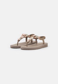 Brown rubber flip-flops with a floral embellishment in pink, white, and mint. Flat soles with a textured grip and adjustable heel strap.