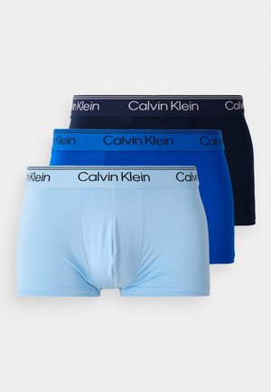 Tri parova bokserica u svijetloplavoj, kraljevski plavoj i tamnoplavoj boji s elastičnim pojasom. Svaki pojas ima logo "Calvin Klein".
