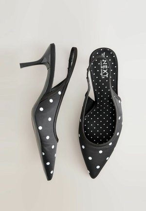 Sorte satin slingback-højhælede sko med hvide polkaprikker, spids tå, høj stilethæl og polstret indersål med matchende prikmønster.