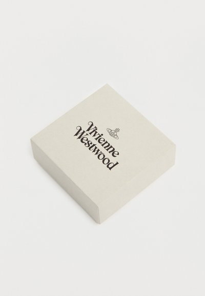 Τετράγωνο μπεζ κουτί με το λογότυπο Vivienne Westwood και το έμβλημα σφαίρας στο κέντρο του καπακιού, τοποθετημένο σε λευκή επιφάνεια.