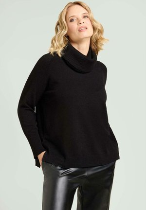 Jersey negro de cuello alto hecho de material suave con puños y dobladillo acanalados. Estilizado con pantalones negros brillantes de cintura alta.