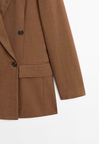 Blazer marrone realizzato in tessuto testurizzato con revers a punta, due bottoni frontali e una tasca sul petto con dettaglio a pattina.