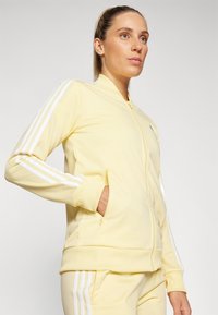 adidas Sportswear ESSENTIALS 3-STRIPES - Treniņtērps - almost yellow/white