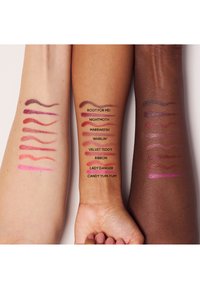 Campioni di colori per labbra applicati su tre braccia con diverse tonalità della pelle, con varie sfumature in linee etichettate con i nomi dei colori.