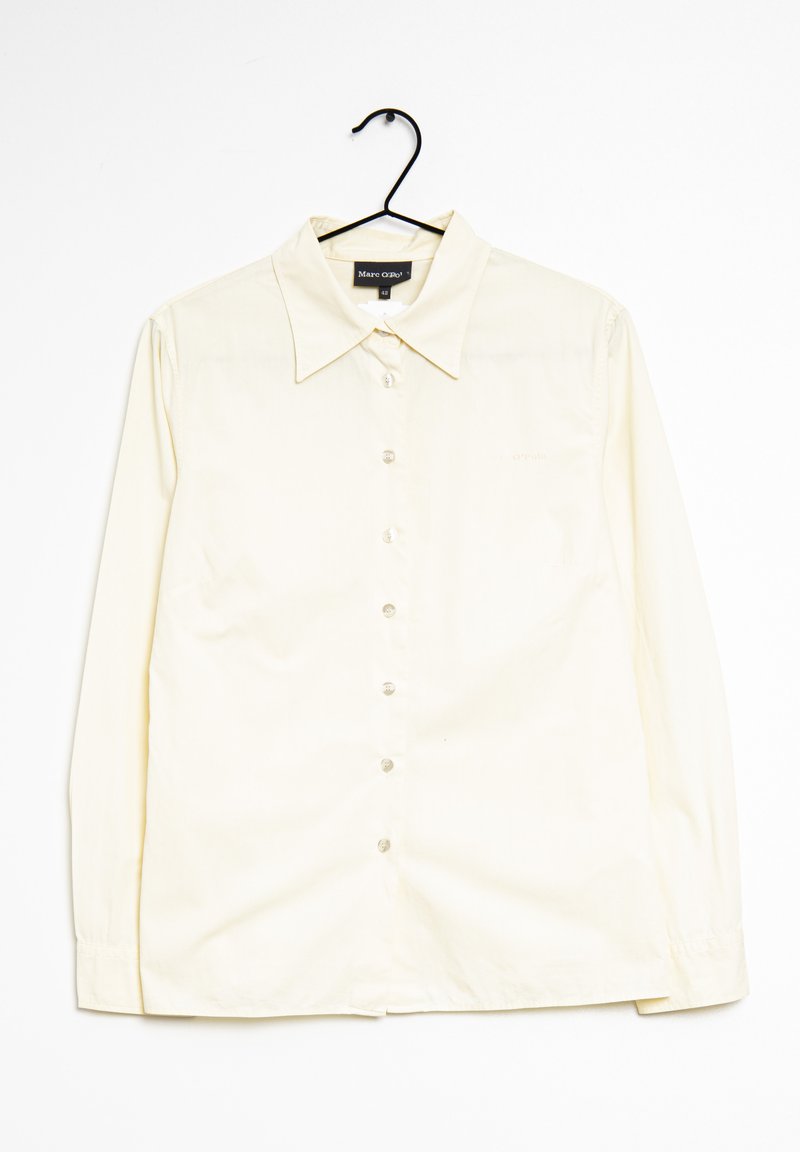 Chemise crème à manches longues avec boutonnière, col pointu et manches à boutons. Présente un subtil logo sur la poitrine.
