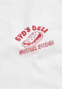 Bílý bavlněný tričko s červenou grafikou zobrazující ilustraci sendviče a textem: "SYDOVO DELI SUPER SUBY!" v tučných, zaoblených písmenech.