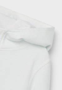 Hvid hættetrøje med en blød tekstur, med en kengurulomme, stitched seams, og et glat, rundet hætte-design.