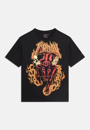 Camiseta negra de manga corta con un toro rojo rodeado de llamas naranjas y la palabra "JORDAN" en letras estilizadas y flameantes encima.