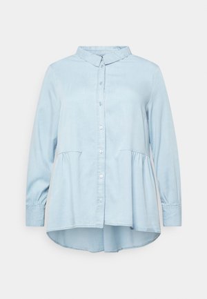 Camicia button-up azzurro chiaro con maniche lunghe, colletto e design peplum. Realizzata in materiale morbido, presenta un orlo curvo.