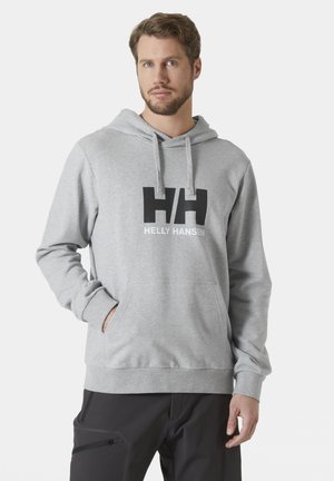Grijze hoodie van stof met een zachte textuur. Heeft een voorzak, trekkoorden en een zwart logo op de borst met "Helly Hansen."