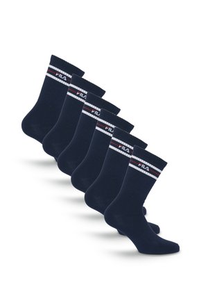 Sześć par czarnych skarpet typu crew z białymi i czerwonymi paskami oraz logo FILA blisko górnej krawędzi, ułożonych w linii ukośnej.