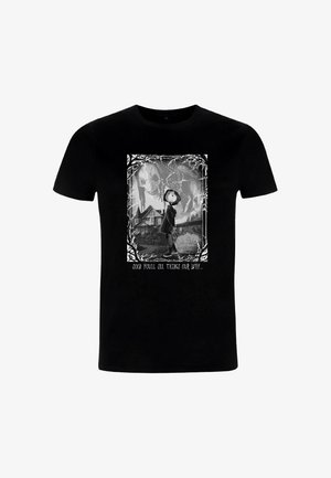 Camiseta de algodón negra con un gráfico monocromo de un personaje con abrigo con capucha, rodeado por un borde decorativo y texto debajo.