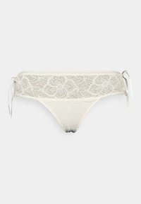 Tanga de renda em creme com padrões florais e laços laterais de cetim; apresenta bordas rendadas e um painel frontal suave e transparente.