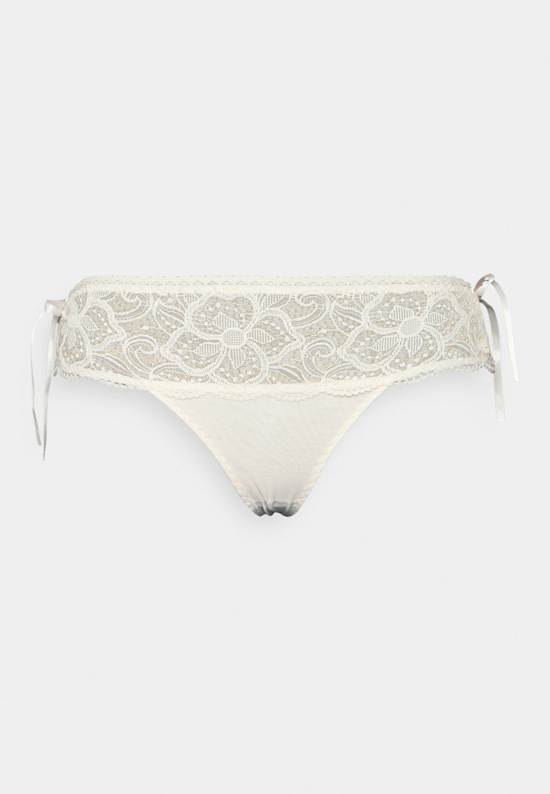 Tanga de renda em creme com padrões florais e laços laterais de cetim; apresenta bordas rendadas e um painel frontal suave e transparente.