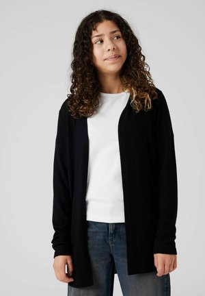 Schwarze, offene Strickjacke aus weichem, strukturiertem Stoff, getragen über einem weißen Hemd und blauen Jeans. Schlichte, entspannte Passform mit langen Ärmeln.