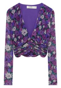 Blouse florale violette à manches longues avec un décolleté en V profond et un détail froncé à l'avant, tissu léger avec un mélange de fleurs violettes, vertes et blanches.