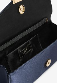 Clutch aperto di colore blu navy con interno in tessuto nero, chiusura magnetica dorata, e etichetta "Lipsy London" nella tasca interna.