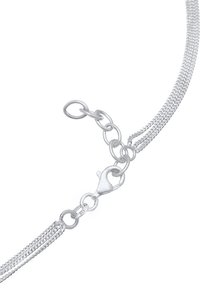 Zilveren ketting met een sluiting en in elkaar grijpende schakels; gladde textuur met een gepolijste afwerking, die het glanzende materiaal benadrukt.