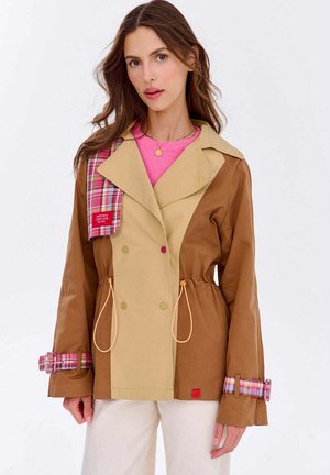 Kurtka w stylu color-block w odcieniach brązu i beżu, z kratkowymi akcentami na kołnierzu i mankietach, z wcięciem w talii oraz dużymi guzikami.