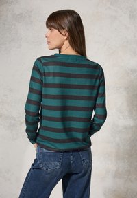 Langarmshirt mit türkisfarbenen und dunkelgrauen horizontalen Streifen, aus einem weichen Stoff gefertigt. Hat einen runden Ausschnitt und eng anliegende Ärmel. Jeans sind am unteren Rand sichtbar.