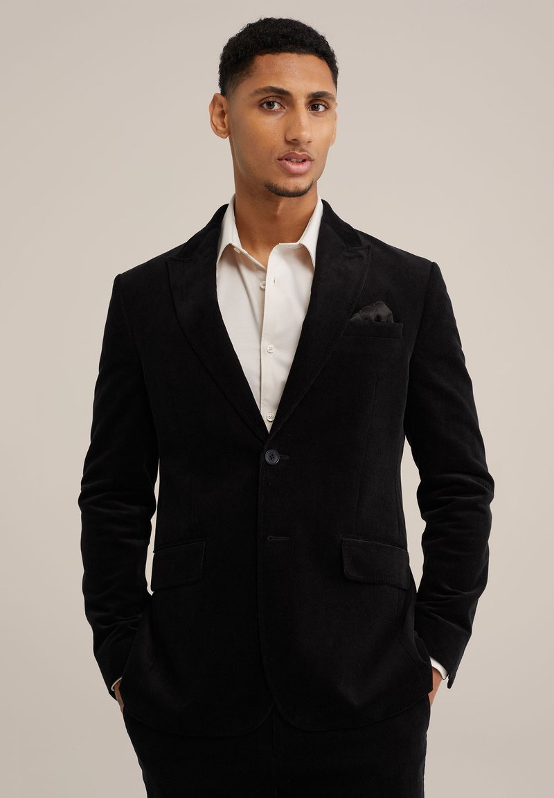 Zwarte corduroy blazer met reverskraag, twee voorzakken, enkele knoopsluiting en een zakdoek in de borstzak.