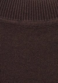 Gros plan d'un tissu tricoté côtelé marron foncé avec une texture de couture visible et un détail de couture horizontale.