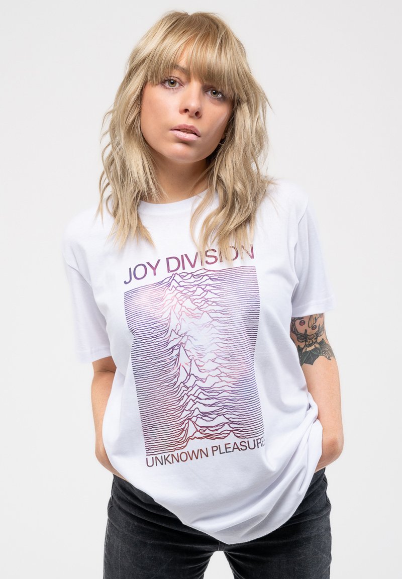 White short-sleeve t-shirt featuring purple and black graphic design with "JOY DIVISION" and "UNKNOWN PLEASURES" text. Soft cotton material.